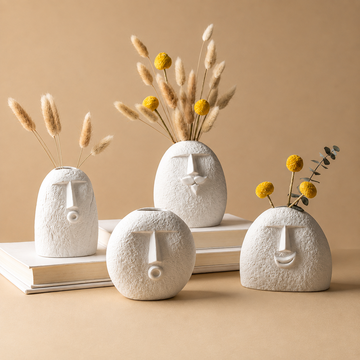 Abstract face vases with dried botanicals on white surface