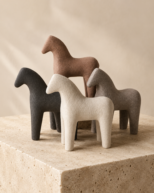 Set of four abstract horse sculptures in earthy tones on stone pedestal