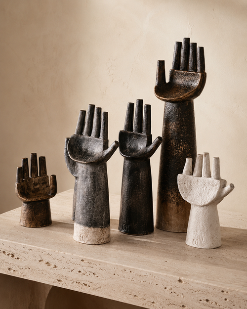 Set of five abstract hand sculptures in dark bronze and cream on travertine shelf