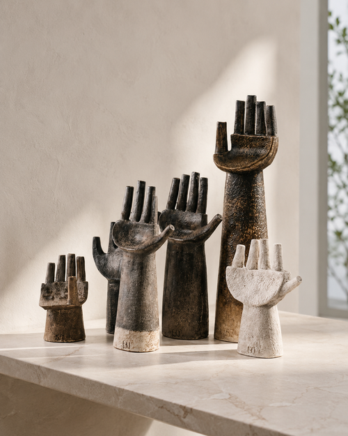 Abstract hand sculptures on marble surface with natural window light