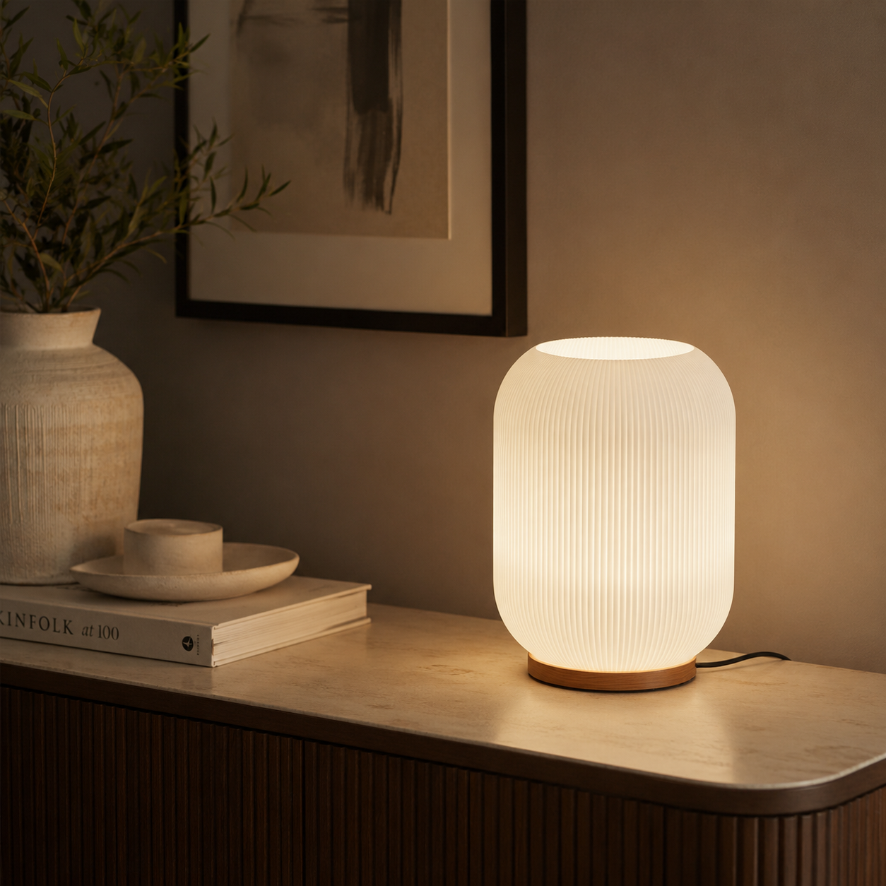 Ribbed glass lamp on sideboard with ceramic vase and warm ambient light