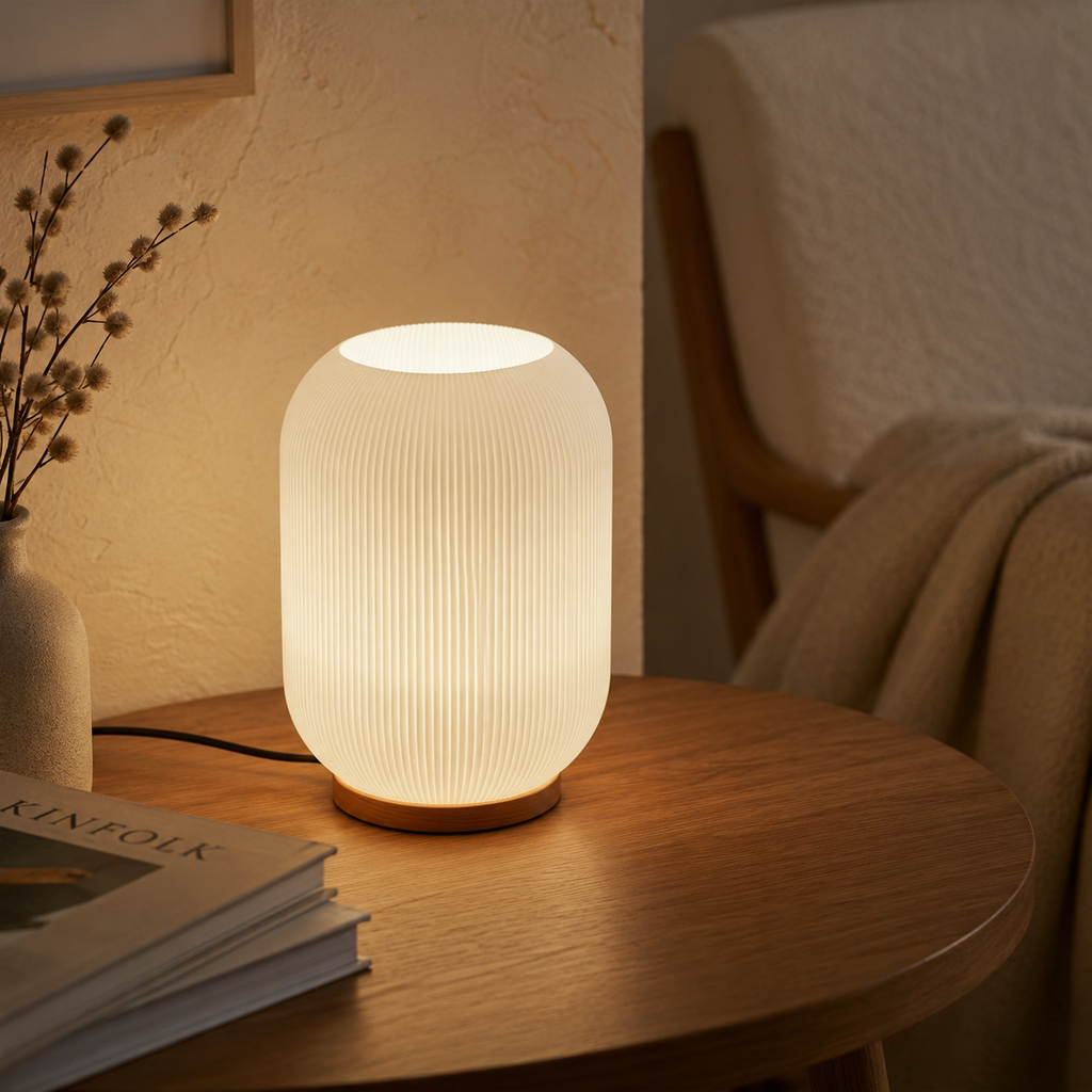 Frosted ribbed glass table lamp on round wooden side table beside armchair