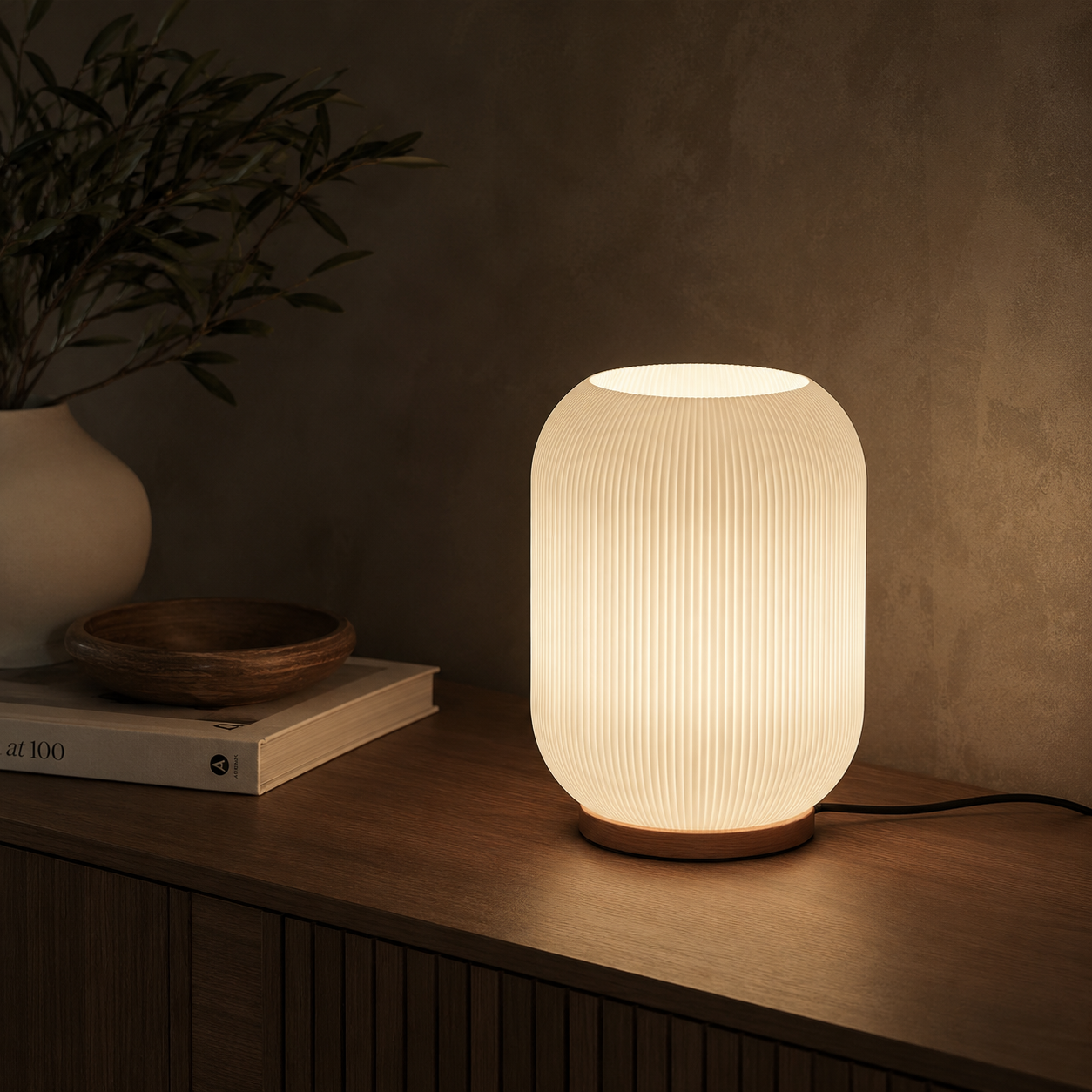Ribbed glass lamp on dark wooden console with warm evening glow