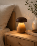 Wooden mushroom lamp glowing warm amber on oak bedside table