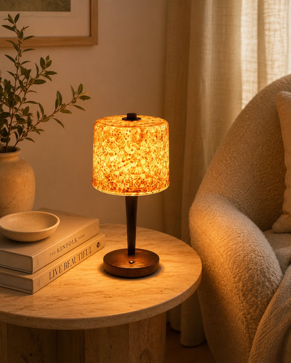 Terrazzo glass lamp on round marble side table beside armchair with books