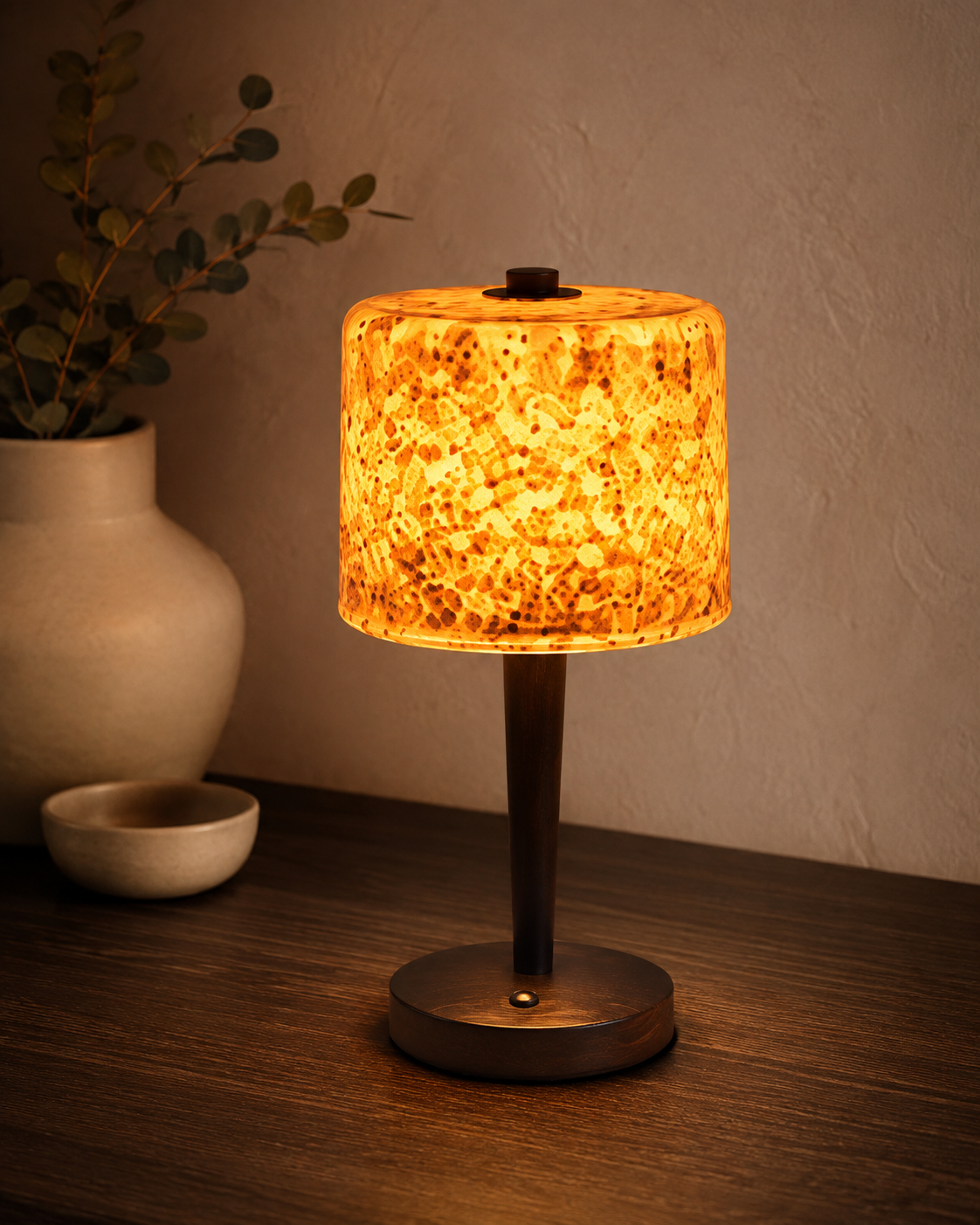 Amber terrazzo table lamp on dark wooden console with eucalyptus and ceramic vase